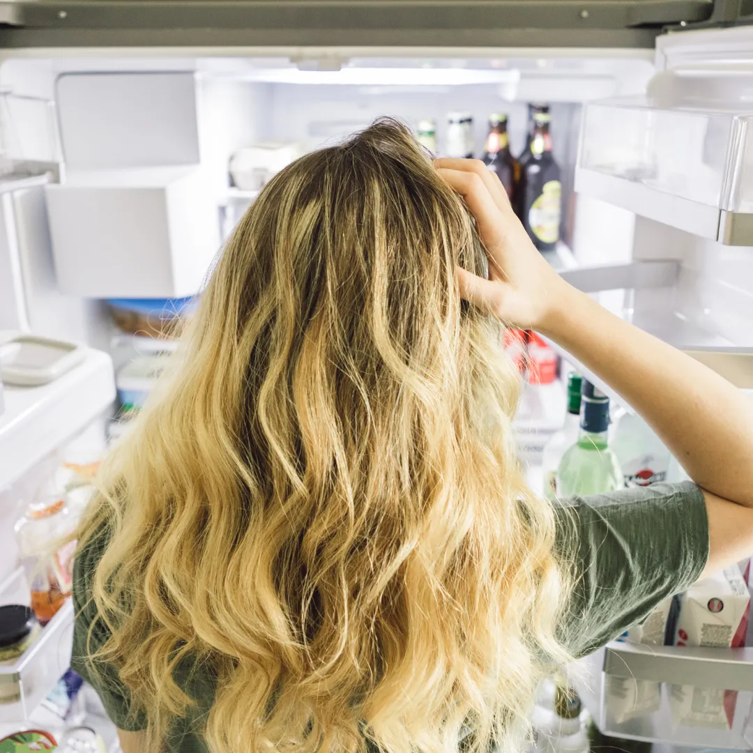 woman confused looking inside of fridge