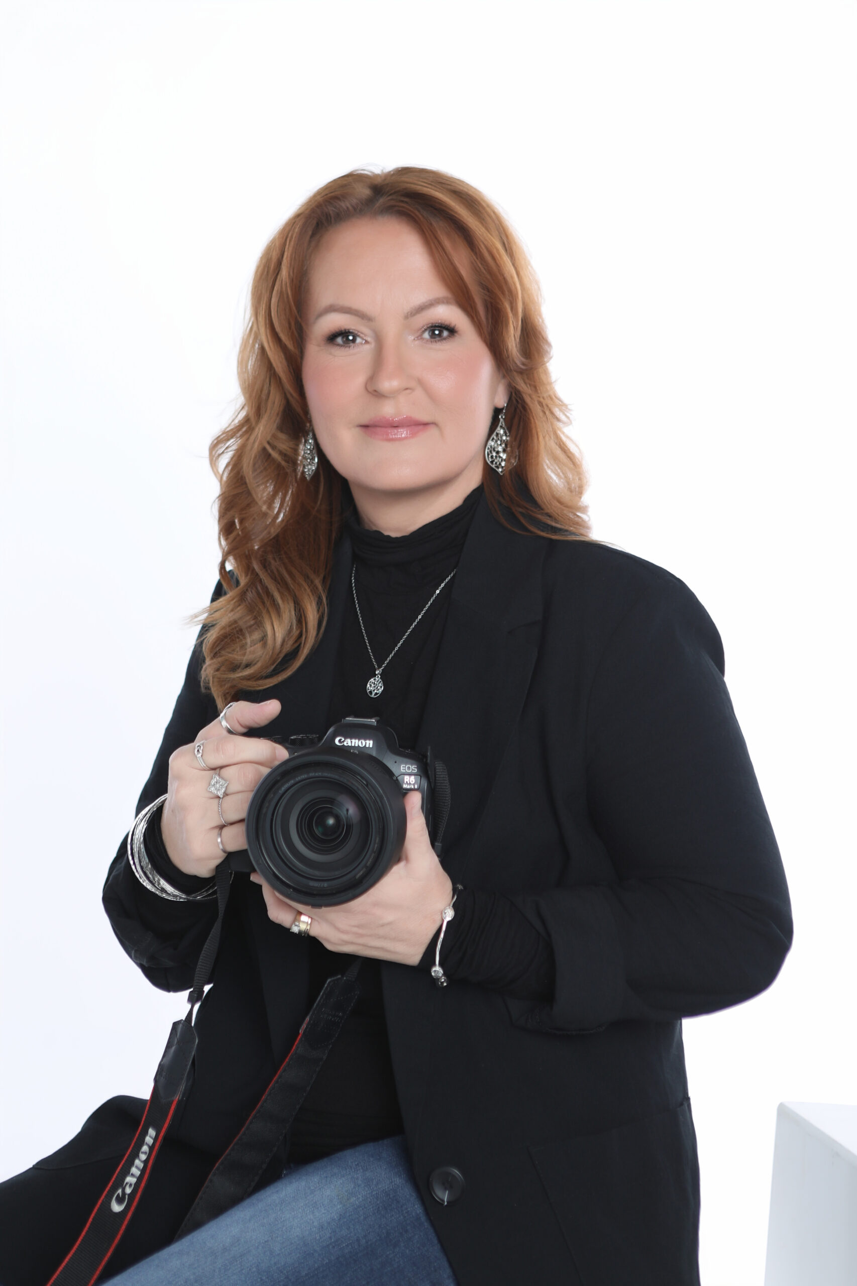 Linda Guerra, a Latina woman in her 30s, smiling warmly in a sunlit studio, surrounded by camera gear and design sketches, 1:1 aspect ratio