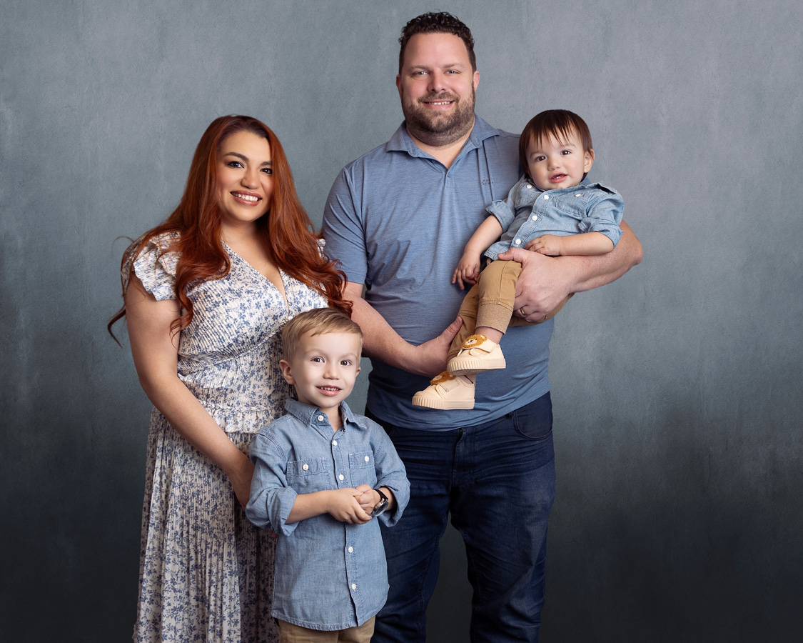 A candid photo of a diverse local family laughing together in a sunlit park, with soft natural light and gentle bokeh, evoking warmth and connection. The composition is 3:2, with a subtle artistic touch and a welcoming, authentic atmosphere.
