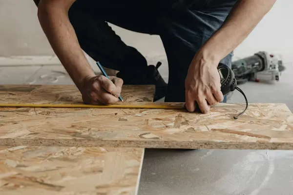 Manitas midiendo y cortando un tablero