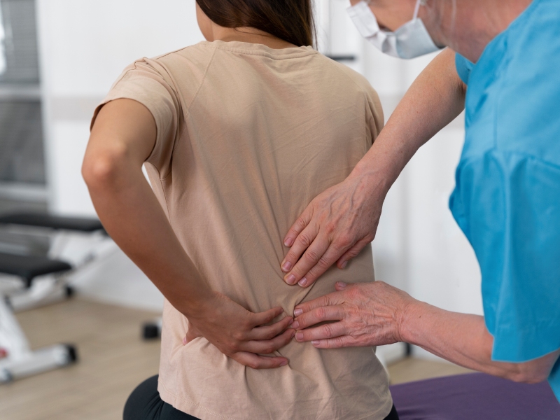 Chiropractor examining a patient’s lower back during a back pain treatment session in a professional chiropractic clinic