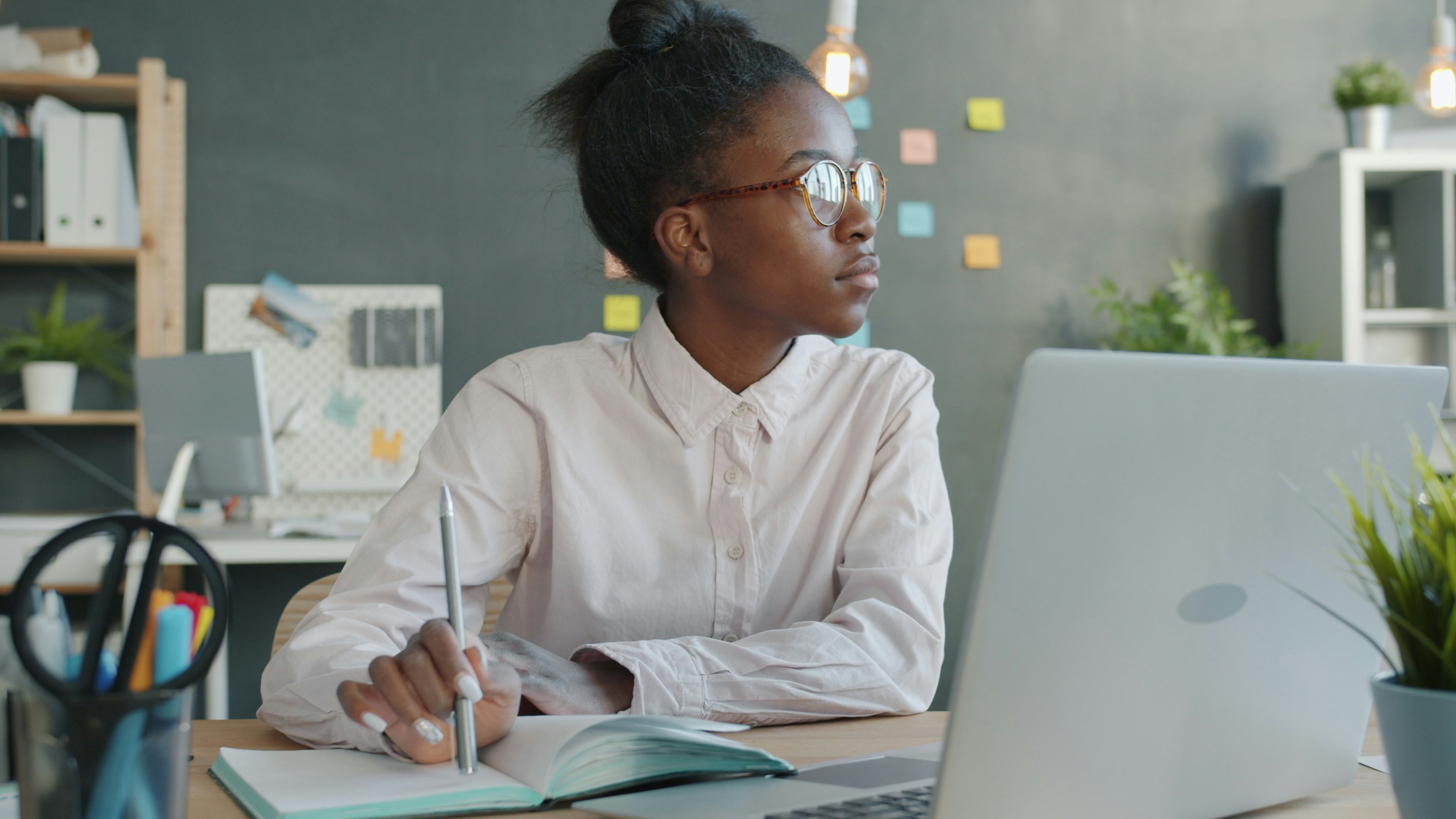 Photo by Vitaly Gariev on Unsplash. Black woman at desk looking out of window