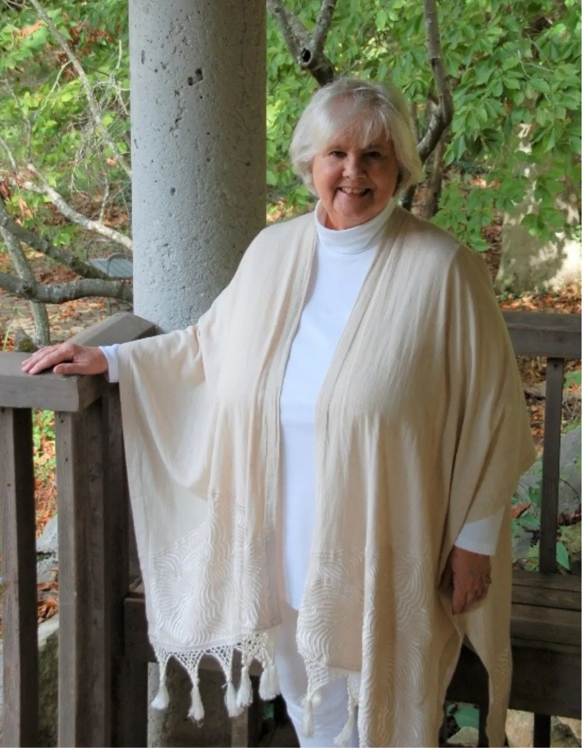 Portrait of Vaishnavi Roberson, Ph.D., standing on a wooden bridge surrounded by nature, representing her lifelong journey of integrating ancient Vedic wisdom with modern psychological insight.