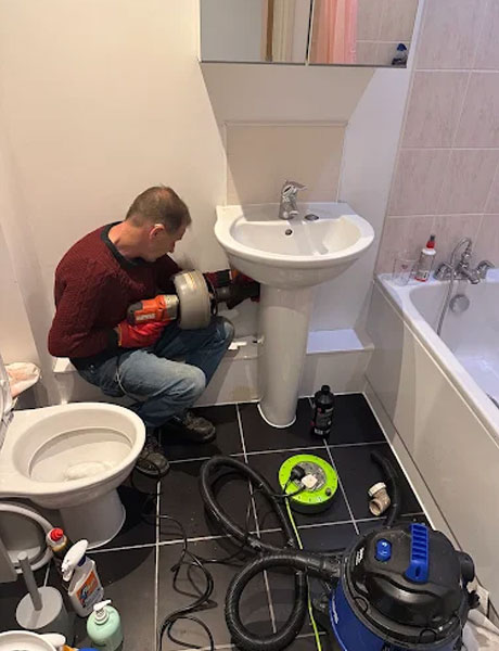 Plumber with customer n the kitchen