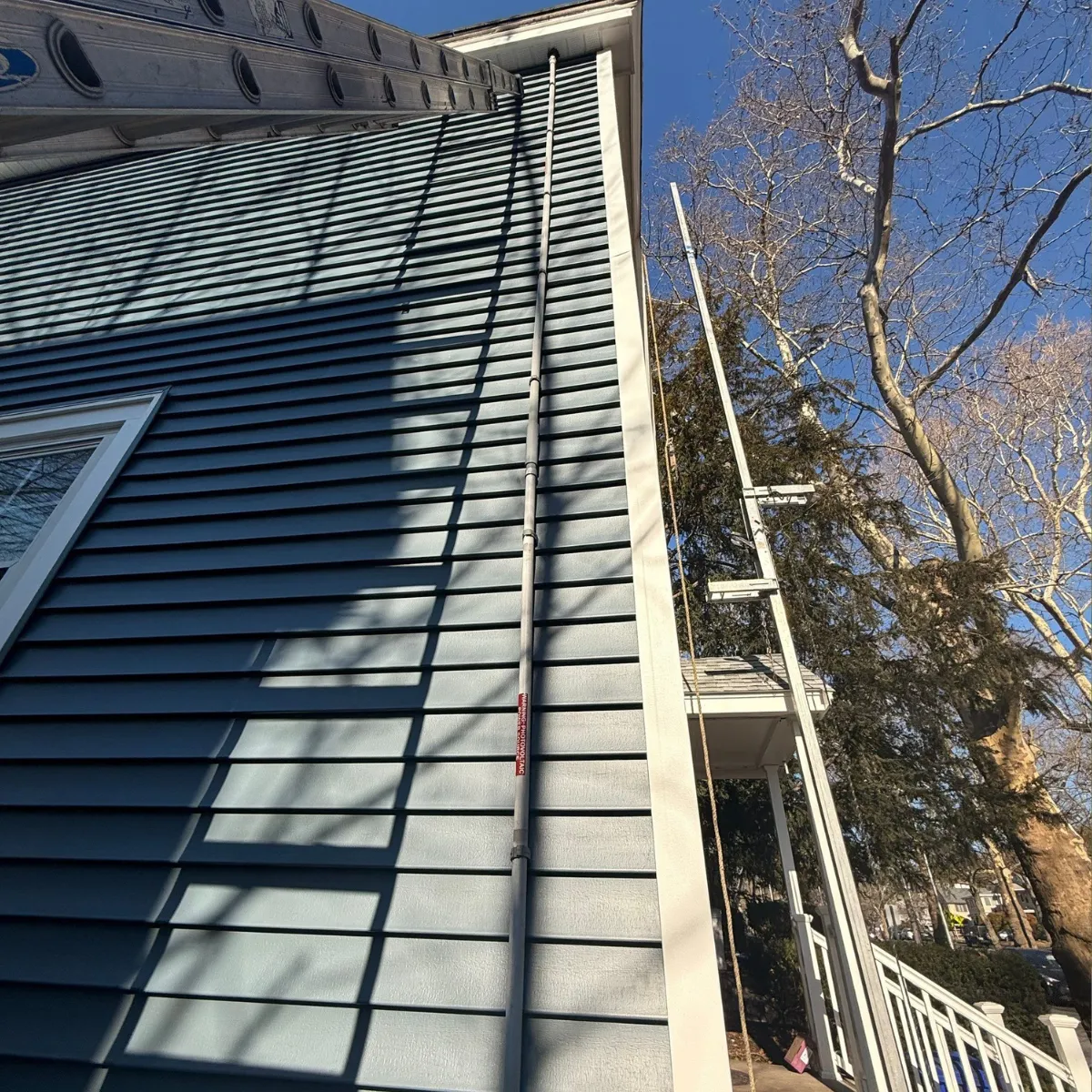 siding installation Melrose MA residential home exterior with vinyl siding and ladder setup