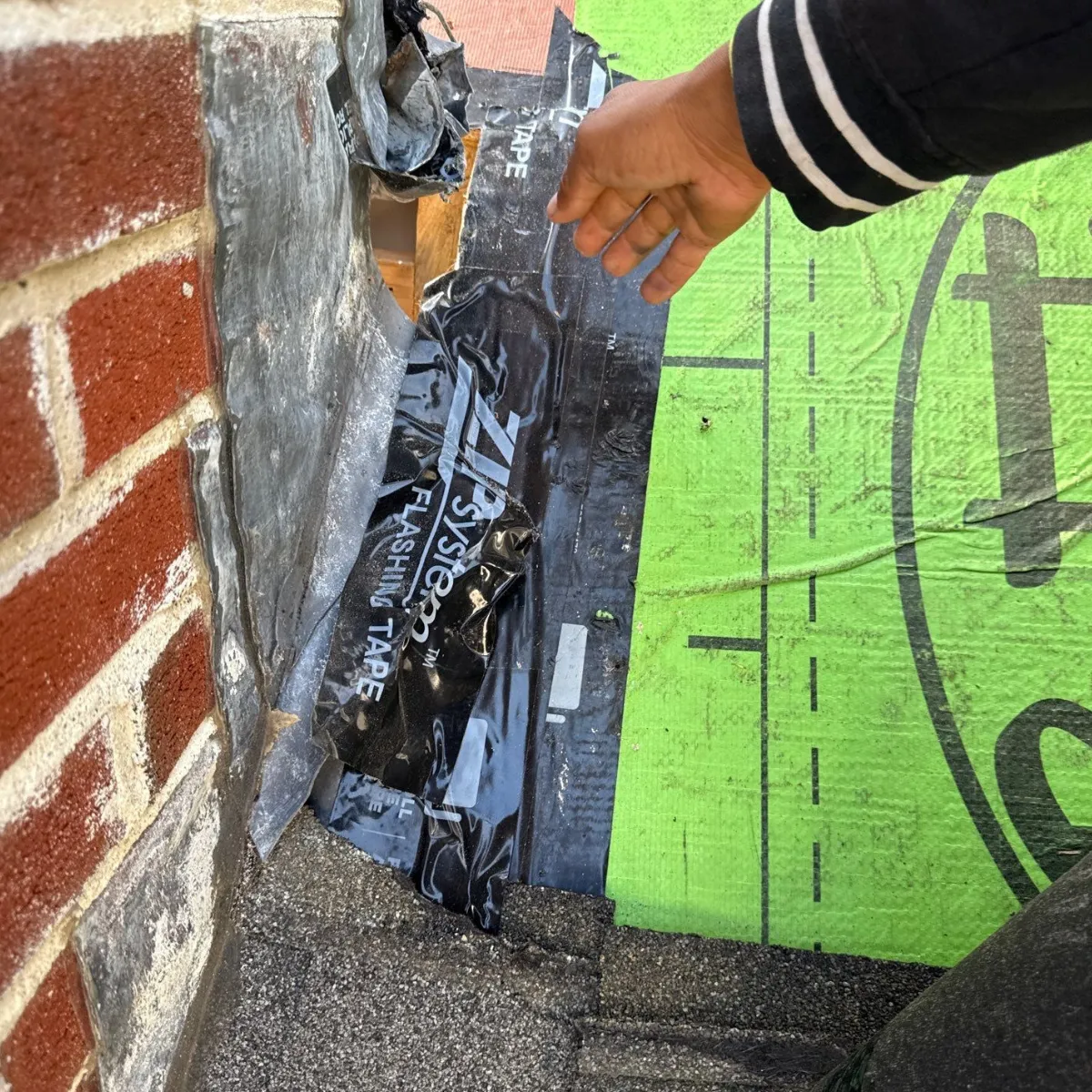 roof inspection Melrose MA worker inspecting aging asphalt shingles on sloped residential roof