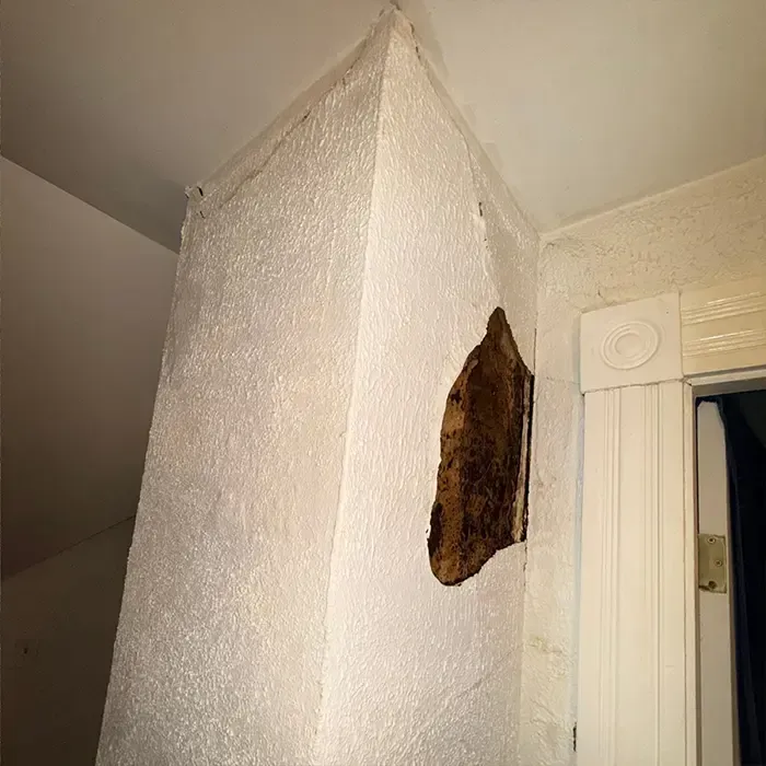 Interior wall damage from chimney leak showing water stains and drywall issues