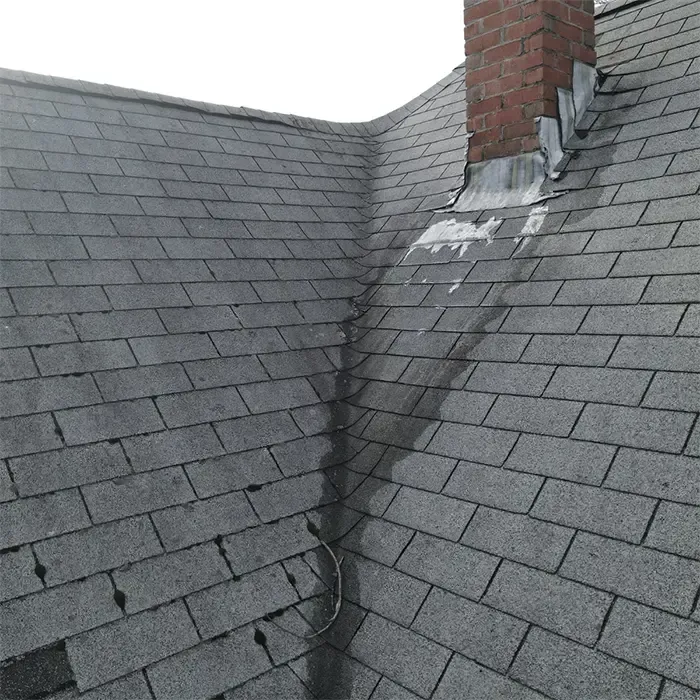 Roof chimney with worn flashing and shingle wear in Greater Boston home