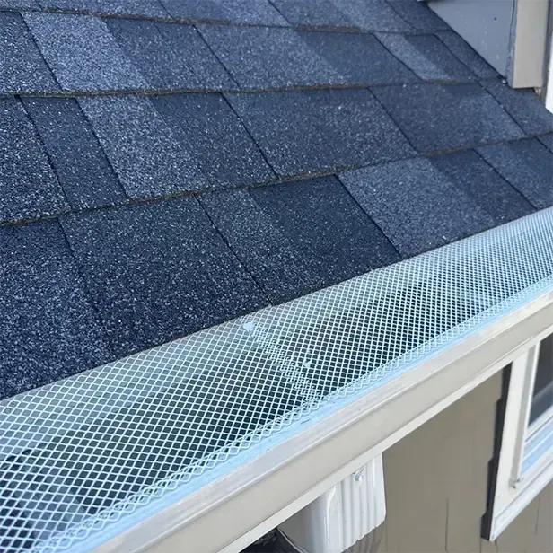 Mesh gutter protection system on asphalt shingle roof