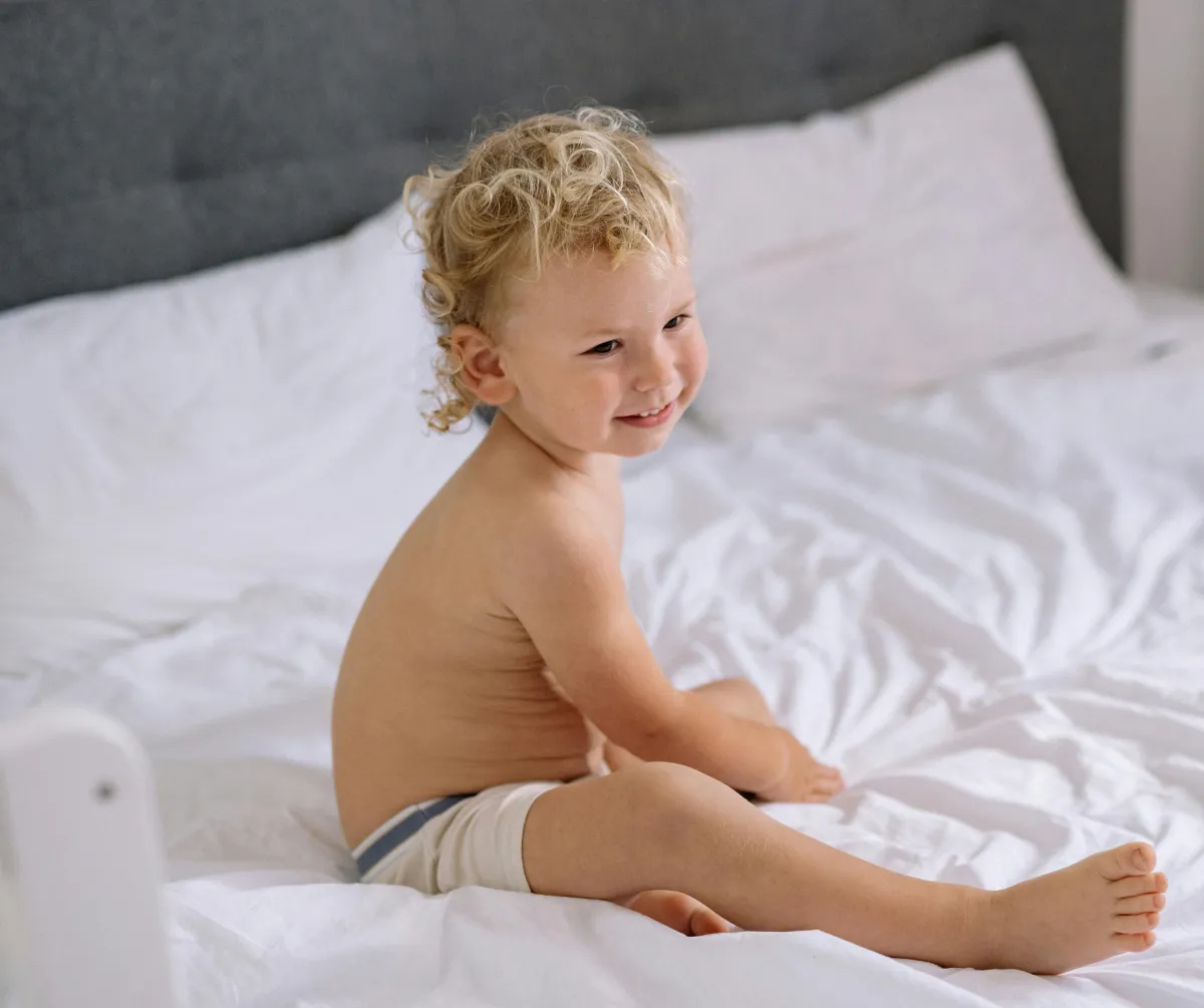 Toddler sleeping with comforter as part of a toddler sleep training program for ages 2 to 4 years