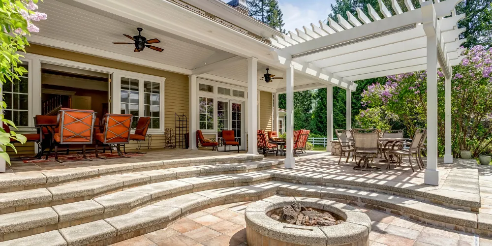 Hardscape design with circular paver patio, built-in fire pit, and surrounding landscaping