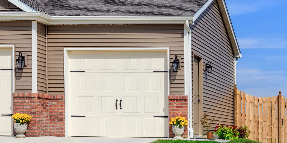 Exterior home renovation showing new siding, garage door, and updated trim work