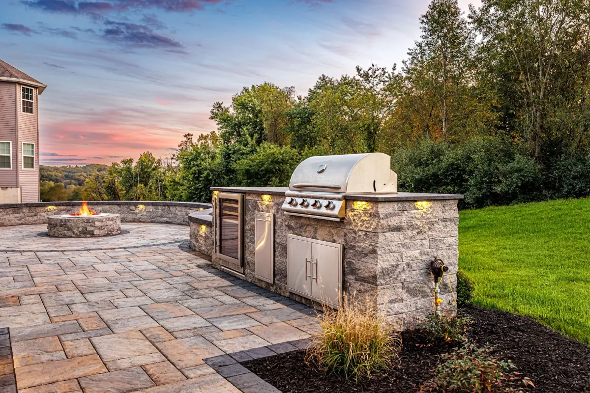 Custom outdoor kitchen island and paver patio crafted by a landscaper in Ambler, PA.