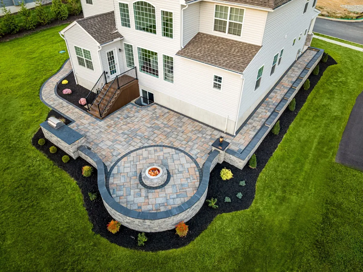 An aerial view of a stone patio with a fire pit built by a professional landscaper in Bridgeport, PA.