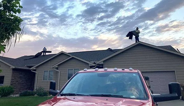 expert roofers working on the top of the house