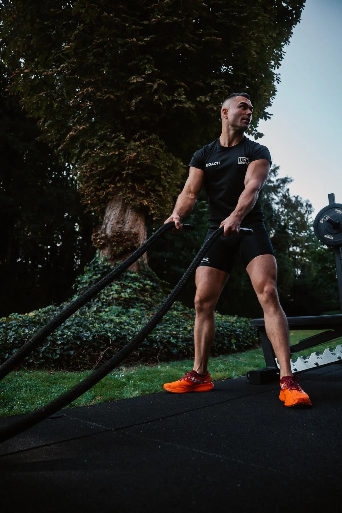 Coach begeleidt sporters tijdens HYROX-training op hun niveau