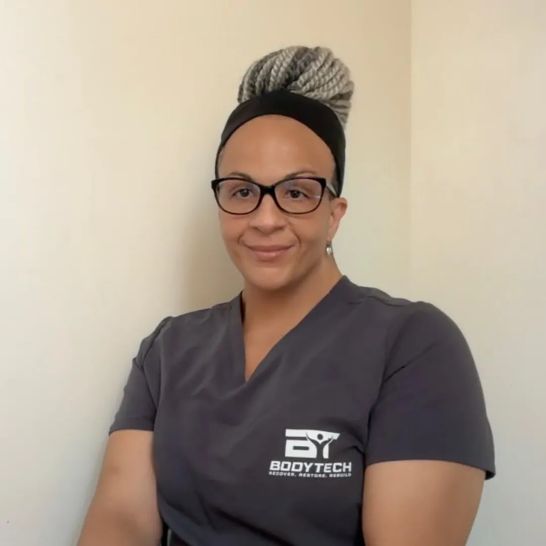 Portrait of Ms. Nguyen, a young Asian female massage therapist with long black hair in a low bun, wearing a crisp white uniform, smiling gently in a softly lit treatment room. She radiates calm, expertise, and compassion.