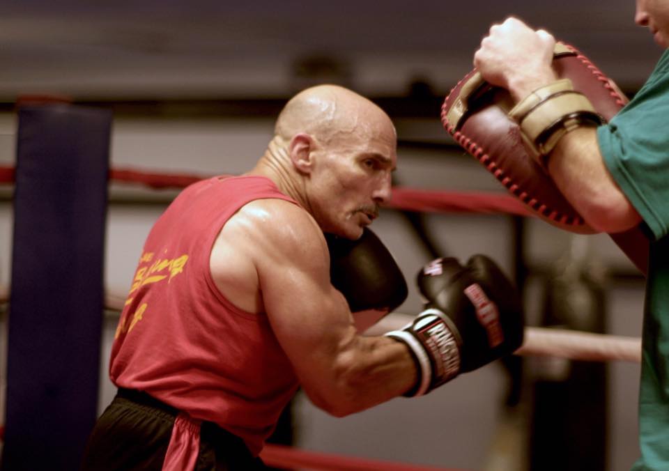 Woman practicing karate in front of city lights