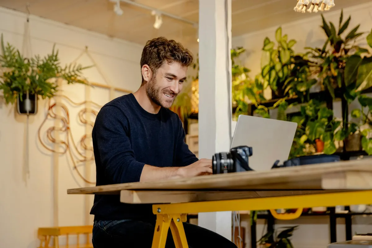 Small business owner working on laptop in his shop
