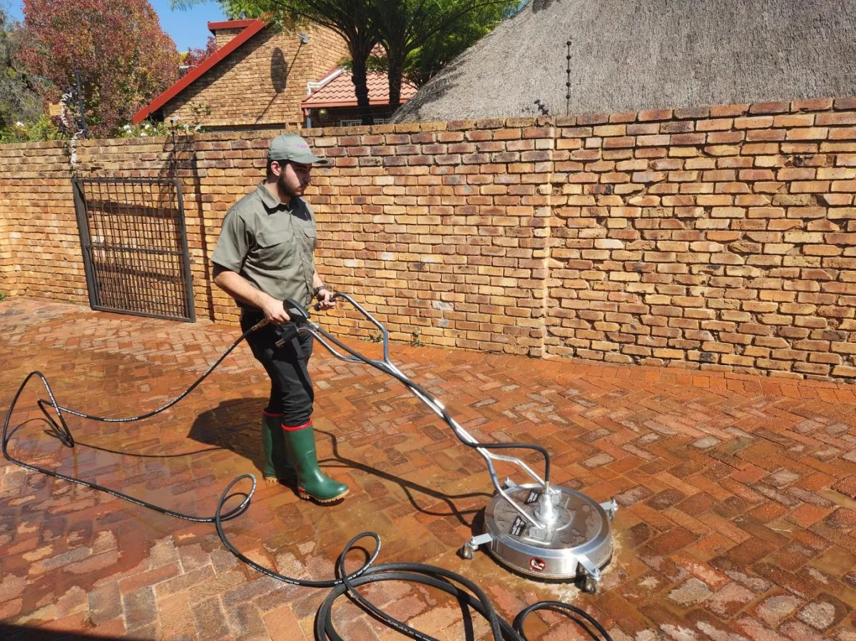Image of a man cleaning a driveway using a pressure washer