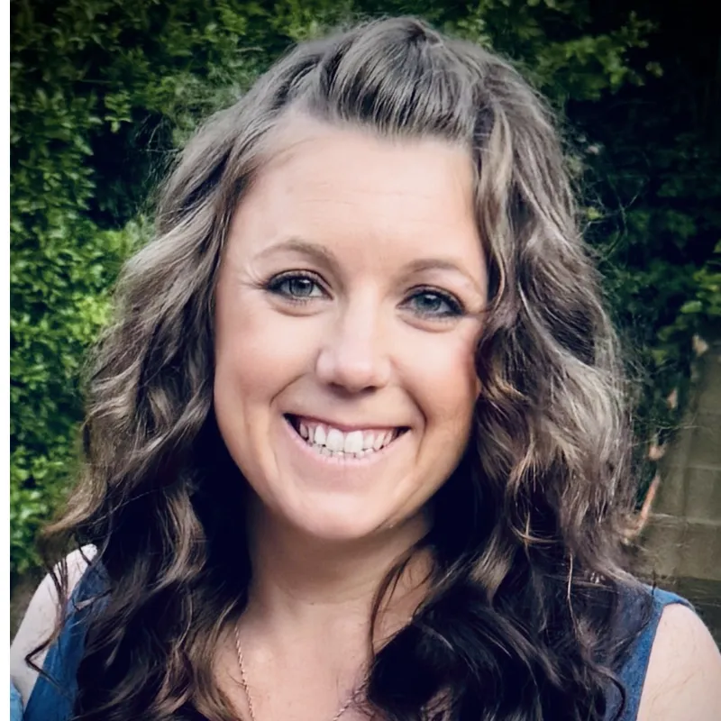 Loan officer smiling in a bright office holding a tablet