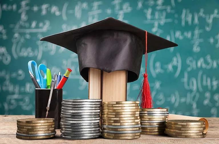 Person using calculator at desk with computer charts.