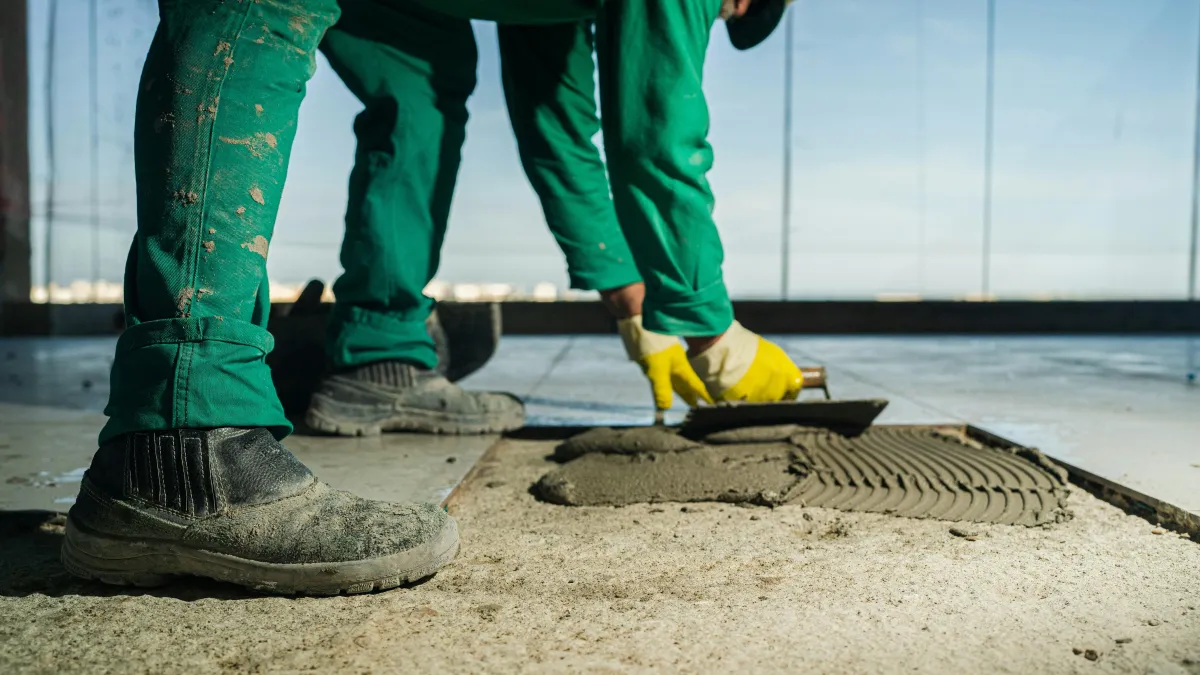 Flooring contractor applying mortar base coat before installing an epoxy floor