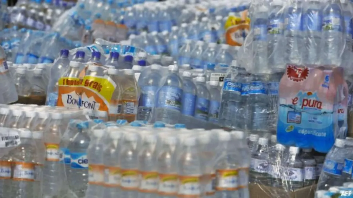 Paquetes de agua embotellada con mensaje informativo sobre riesgos para la salud, como microplásticos, bisfenol A (BPA) y bacterias acumuladas durante el almacenamiento prolongado.