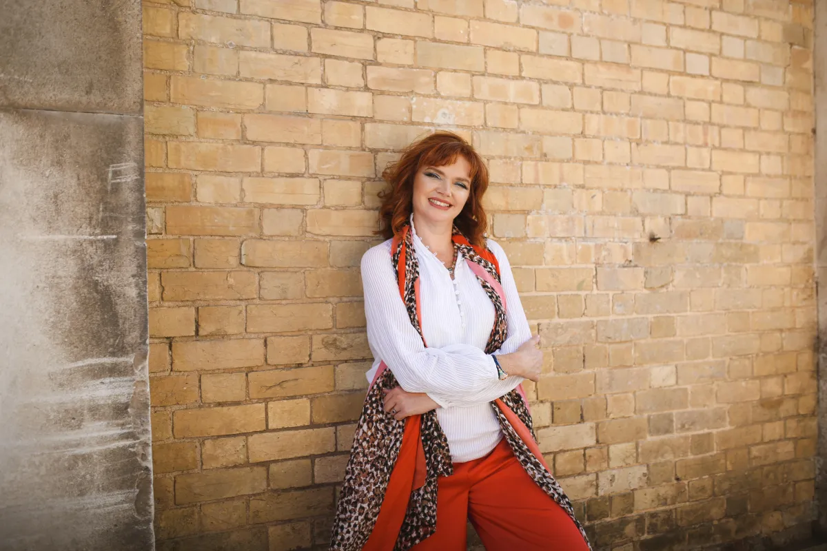 woman leaning agains a brick wall
