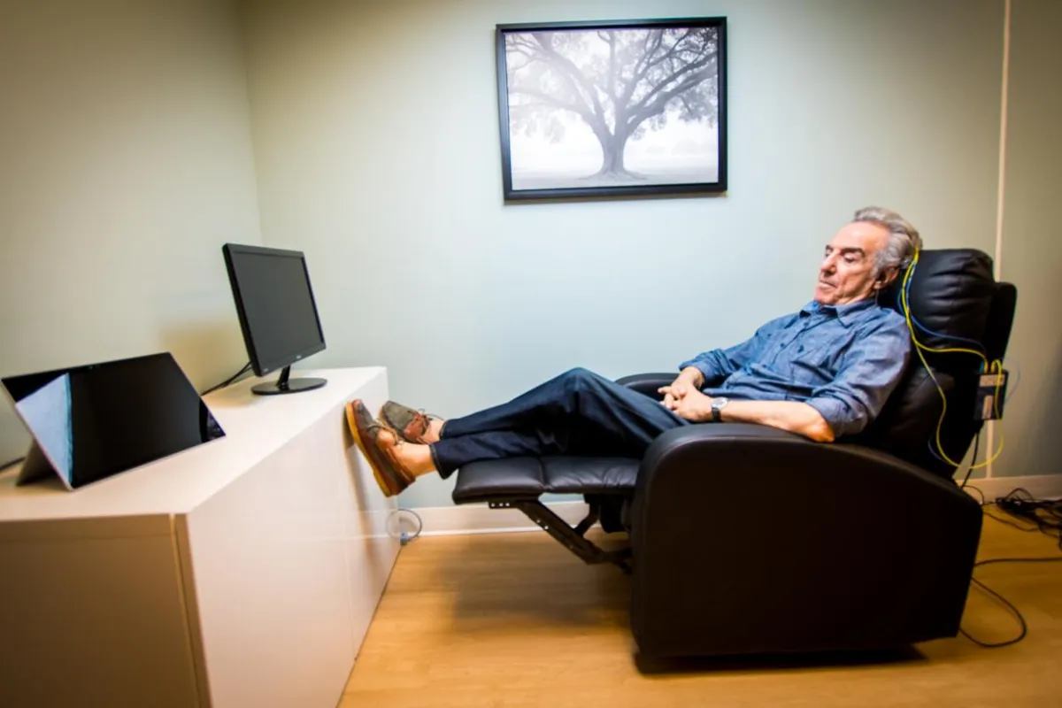 An elderly gentleman enjoying a NeurOptimal® neurofeedback brain training session while reclined in a comfortable chair.