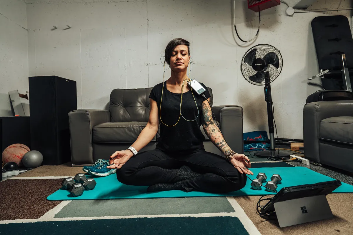 A young woman enjoying the benefits of a NeurOptimal® neurofeedback brain training session while practicing yoga
