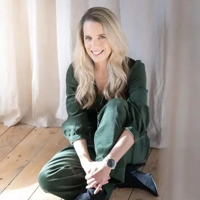 Ellie White, alcohol-free coach and women’s health advocate, seated indoors in natural light.