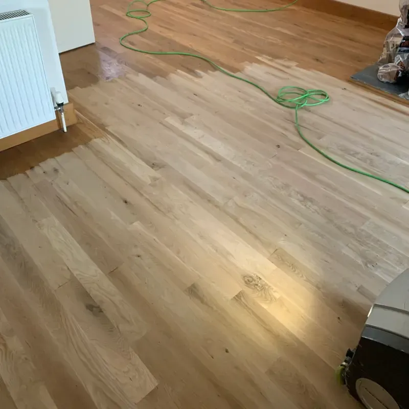 Wood floor restoration in progress with sanded and unfinished areas by Cornwall Floorcare