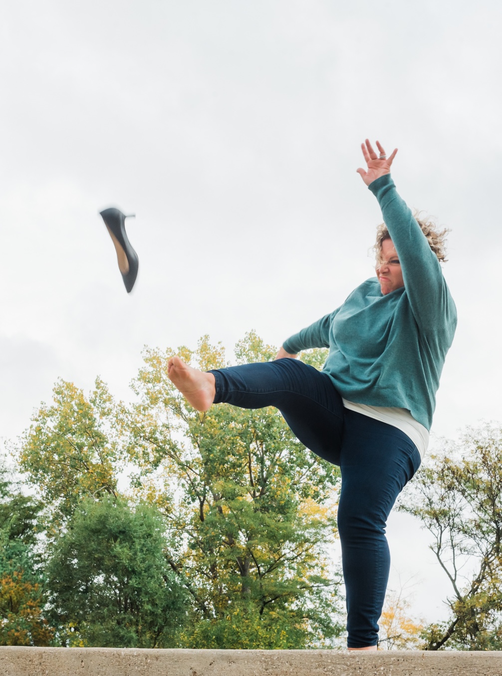 Wendi mid-kick sending a black high heel flying — visual for being done performing and ready to get honest