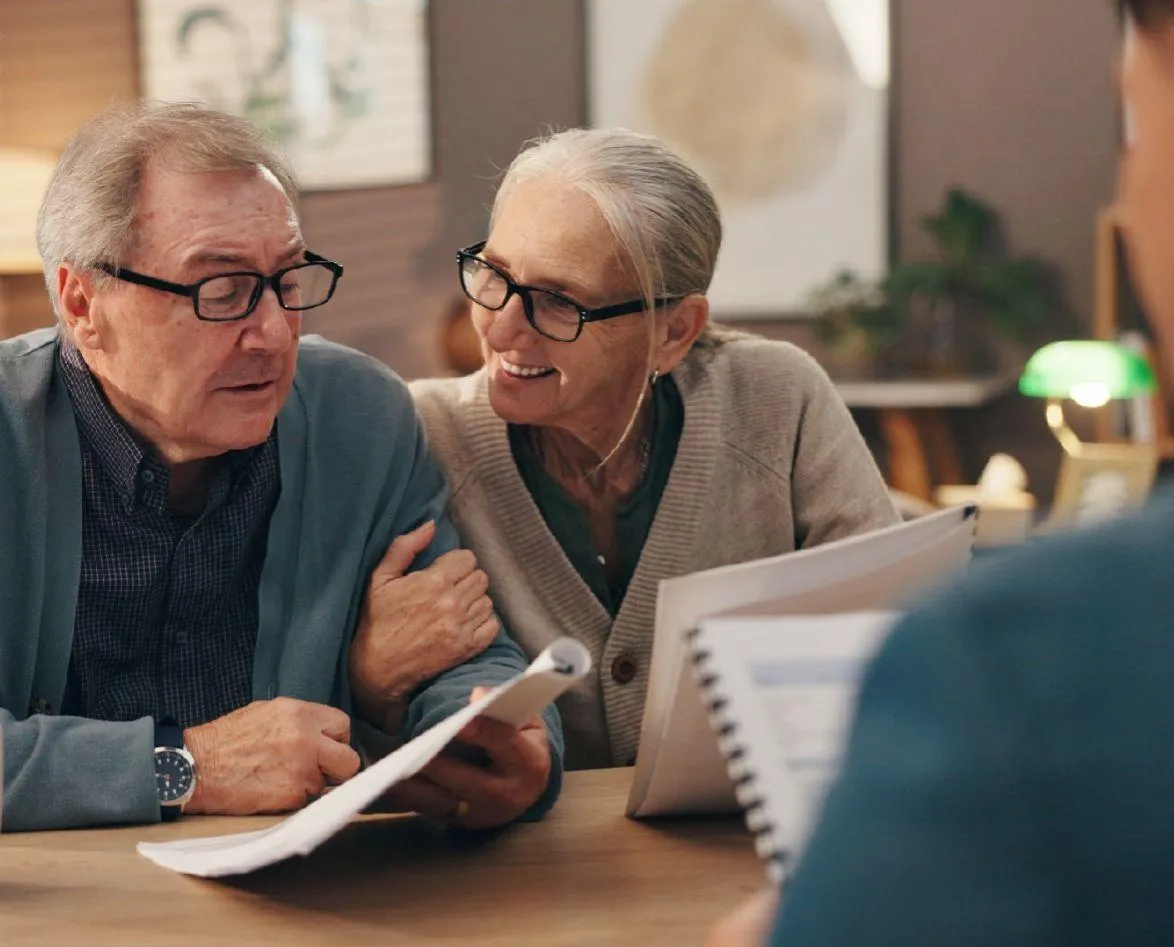 A businessman is holding a laptop and looking up.