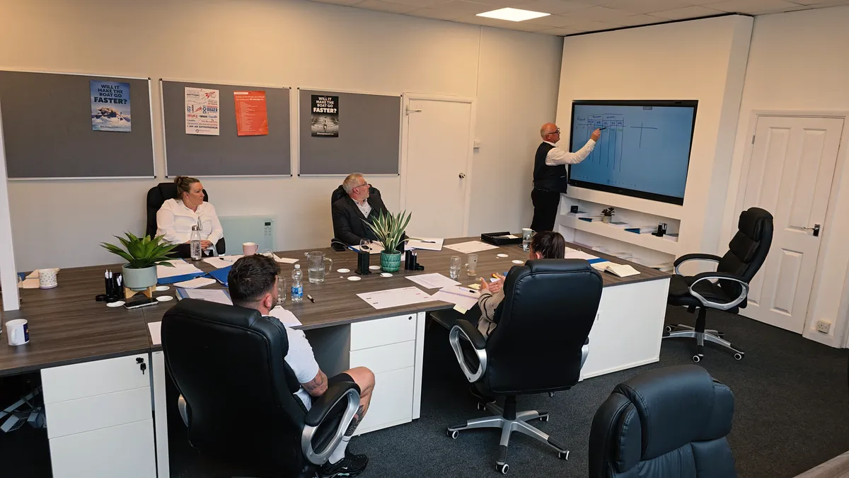 A professional business meeting taking place in a modern training room