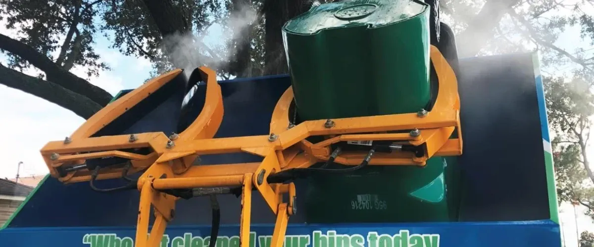 Automated trash bin cleaning truck lifting bins and steaming them clean