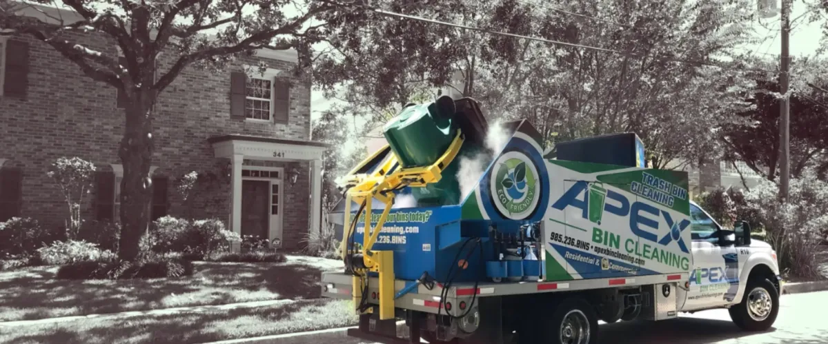 Mobile trash bin cleaning truck servicing residential garbage bins in a neighborhood.