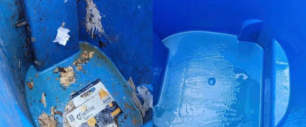 Inside a dirty blue trash can, a Corona Extra beer box lies amidst debris and liquid waste.