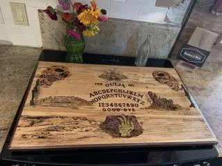 Hand-carved wooden spirit board with burned lettering