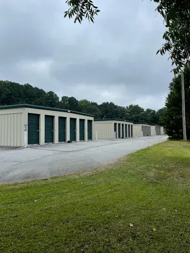 Large industrial warehouse with blue gates and road.