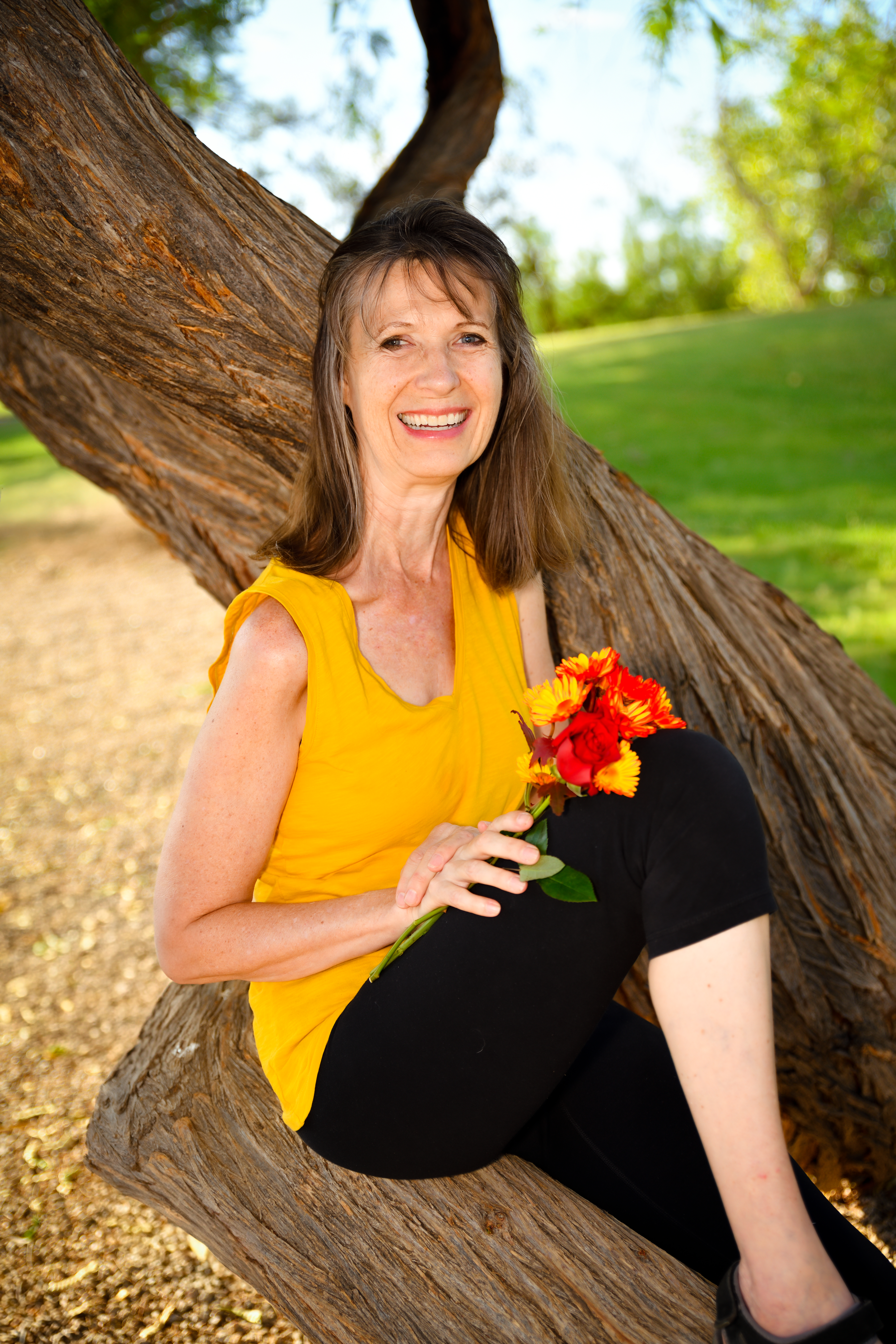 Ilene smiling sitting on a tree