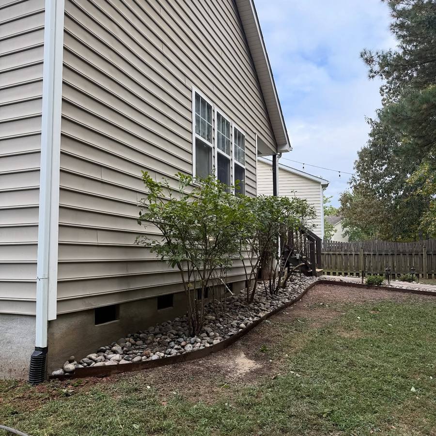 Drainage extension with river rock bed to protect home foundation from erosion in Raleigh NC by MC Landscaping