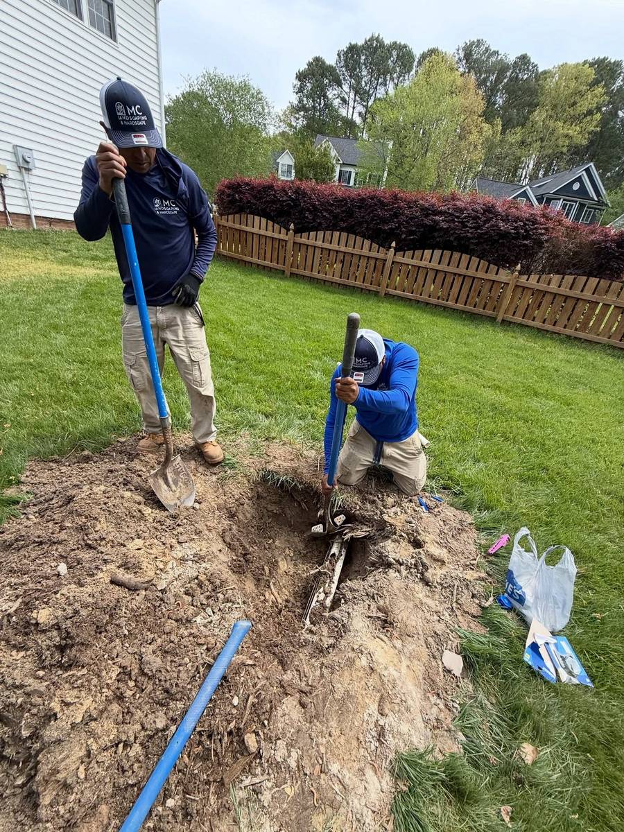 MC Landscaping team installing residential irrigation system with PVC pipe trenching in Raleigh NC