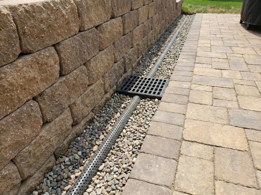 French drain with perforated pipe and surface catch basin installed by MC Landscaping in the Raleigh–Durham area