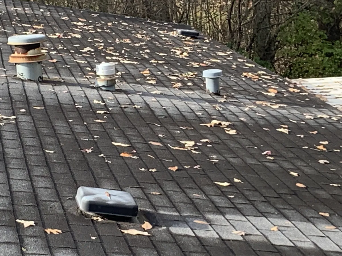 Residential roof being inspected for damage and prepared for winter weather.