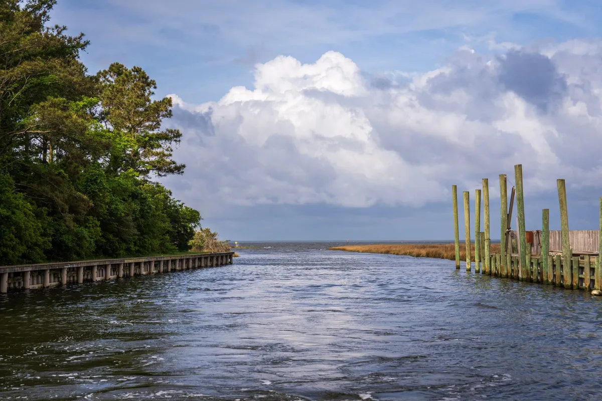 Low wooden bulkhead and pilings lining a tidal creek