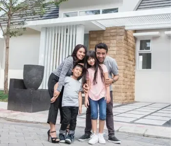 Happy family in front of new modern home in Fremont CA guided by El Claveria for confident, stress-free home buying process