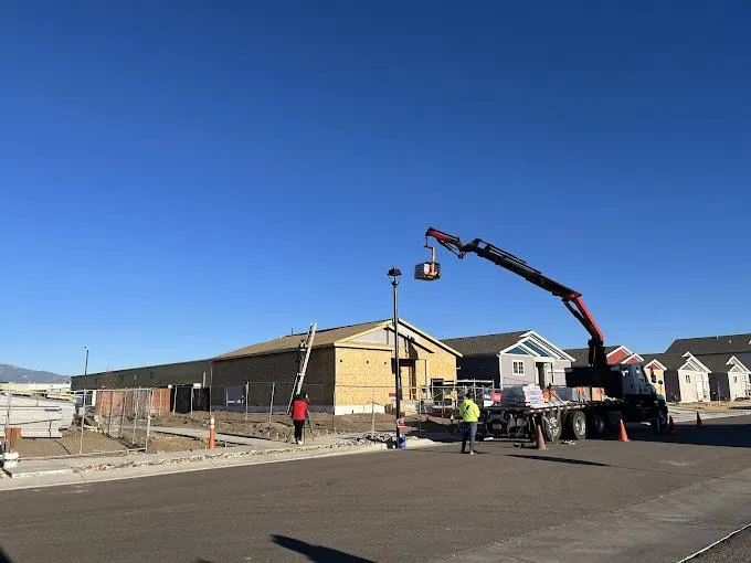 FBC roofing installer carrying a ladder