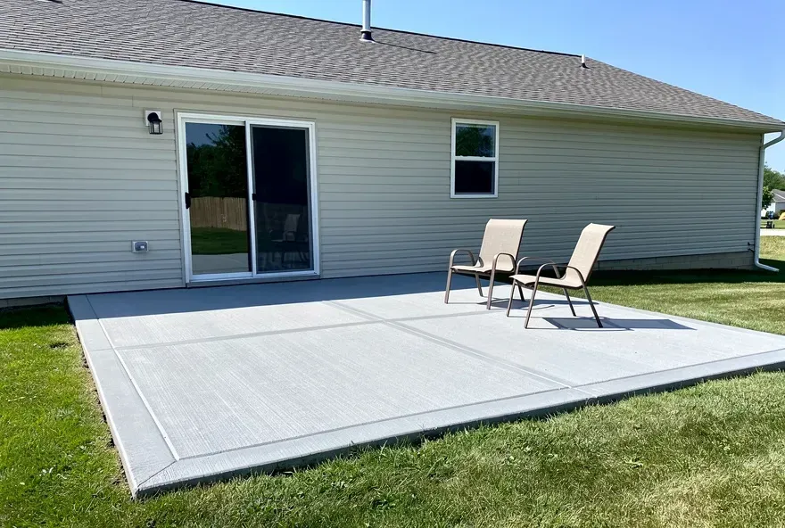 Finished concrete patio attached to the back of a home in Pendleton, Indiana on a sunny day.